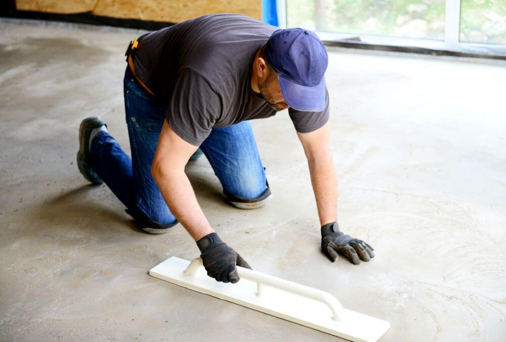 Man smoothing concrete garage floor