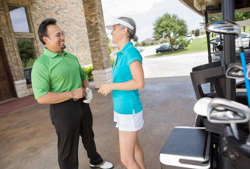 Woman in a tennis suit engaged in conversation with a man.