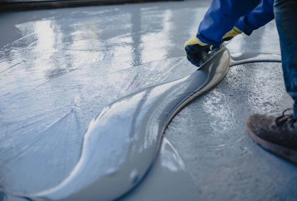 Worker applying concrete sealer for garage