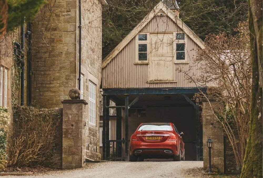 Red car parking in a rustic themed garage space