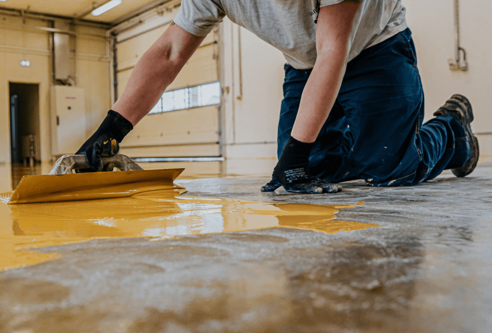 man working on a floor with gloves on his hands han