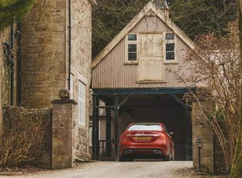 Red car parking in a rustic themed garage space