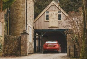 Red car parking in a rustic themed garage space