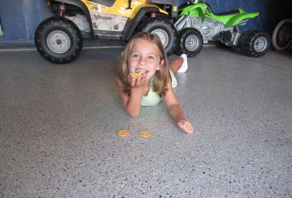 Little girl picking up her food in an epoxy covered floor
