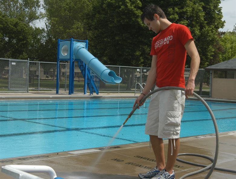 man cleaning the pool deck