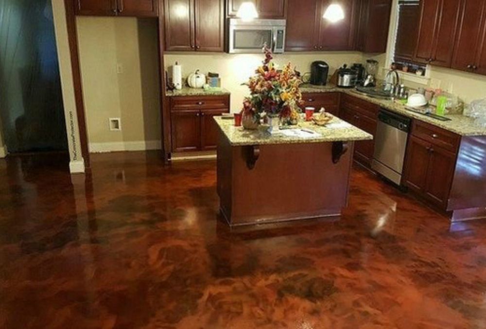 Open-concept kitchen showcasing stained concrete floors with warm tones